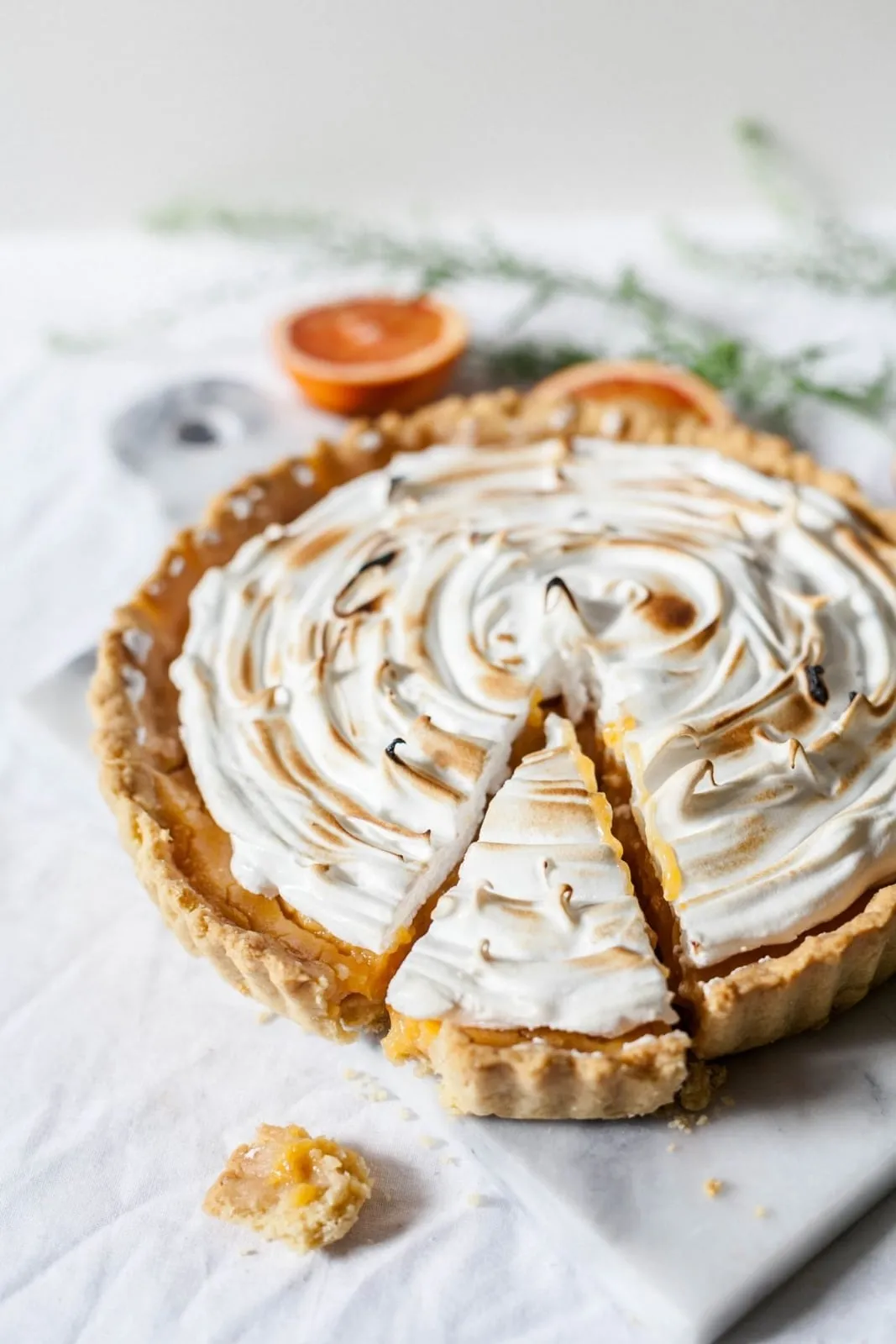 Een citroentaart met meringue op een wit bord.