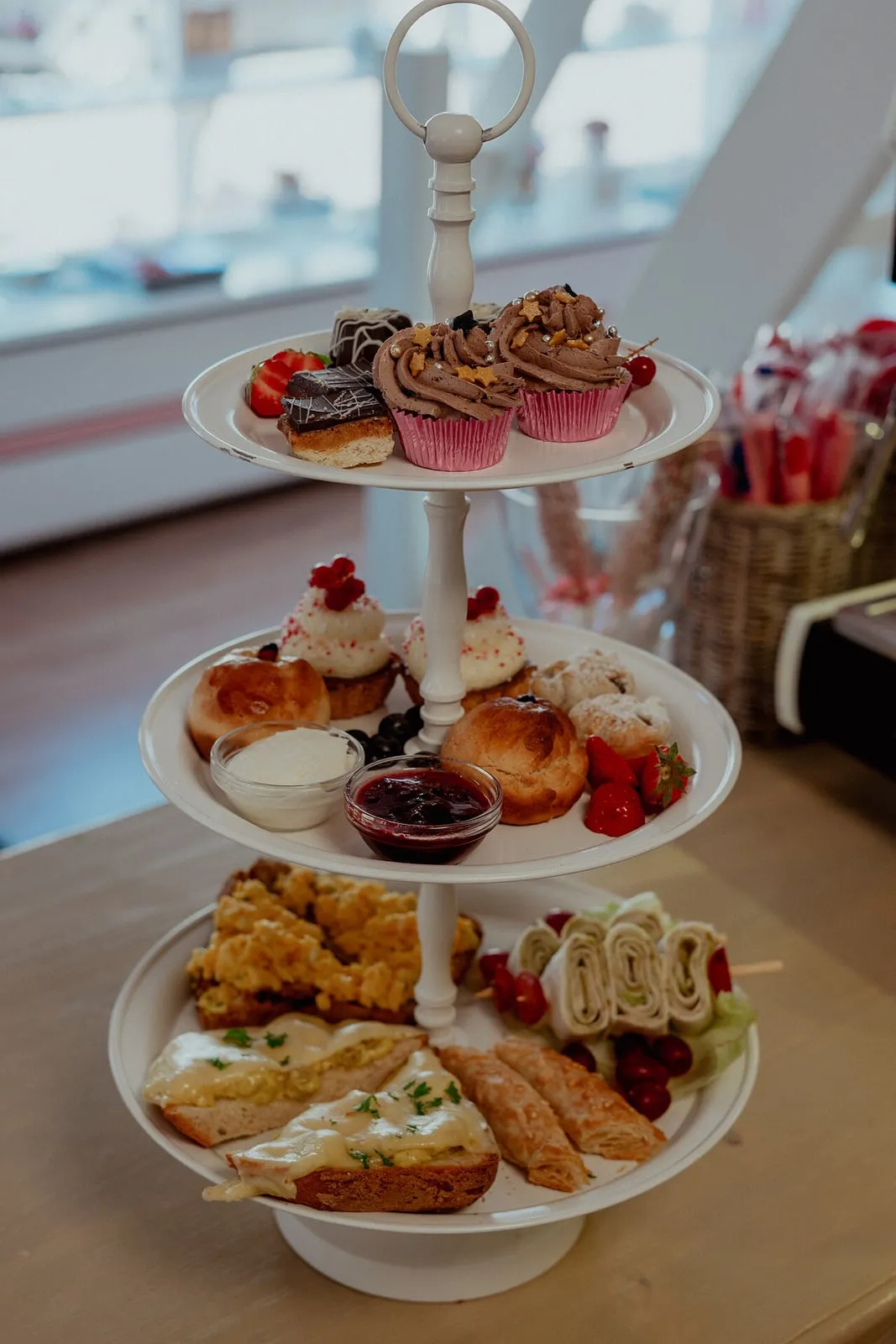 Een etagère met cupcakes, scones met jam en hartige hapjes in het teehûs.